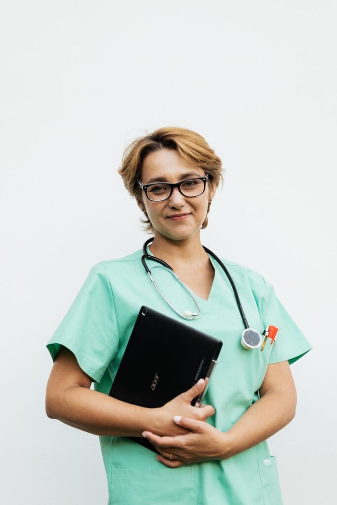 woman in green crew neck t shirt holding black tablet computer